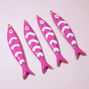 Macro detail of four pink enamel fish pendants with golden edges and scale patterns