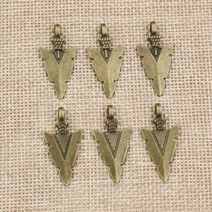6er-Set bronzene Pfeil-Anhänger für DIY-Schmuck auf strukturiertem Leinenhintergrund