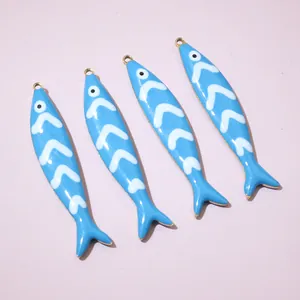 Detailed close-up of blue fish charms with enamel drip finish for DIY jewelry making