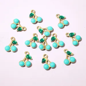 Macro detail of blue enamel cherry pendants with gold finish for DIY jewelry making