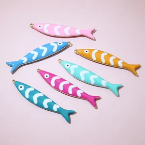 Macro view of colorful enamel fish pendants with gold finish for DIY jewelry crafting