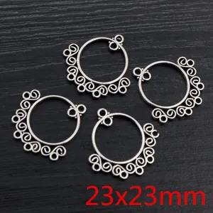 Detailed close-up of 23x23mm antique silver alloy round pendant with scrollwork patterns