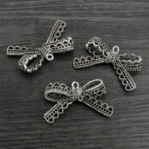 Drei silberne Schleifenanhänger aus Legierung mit Spitzenstruktur für DIY-Schmuck