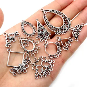 Set of vintage silver alloy DIY jewelry pendants and connectors held in hand