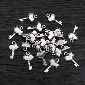 Silver vintage heart key pendants for DIY necklaces and bracelets on wooden background