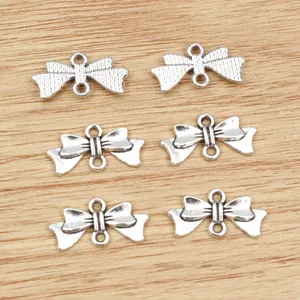 6 Vintage-Silber-Schleifenanhänger aus Legierung für DIY-Schmuck auf Holzhintergrund