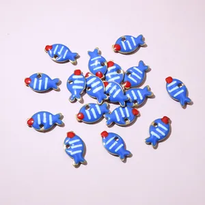Macro view of blue fish pendants with enamel detailing for DIY jewelry making