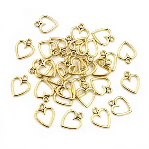 Polished gold alloy hollow heart charms for DIY jewelry making on white background