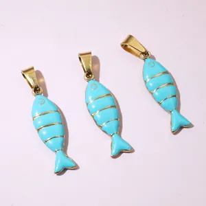 Close-up of light blue enamel fish pendants with golden stripe details and metal loops