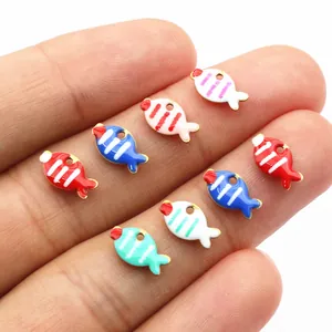 Colorful stainless steel fish charms for DIY jewelry making shown on fingertips