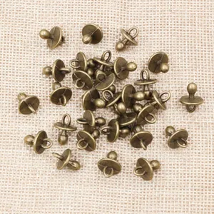 Macro view of bronze pacifier charms for DIY jewelry making on burlap background