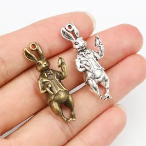 Detail of 3D rabbit charms in bronze and silver showing intricate suit and pocket watch