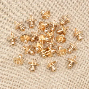 Detailed macro view of multiple gold pacifier-shaped alloy charms for DIY jewelry making
