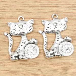 Detailed macro of two antique silver lucky cat pendants for DIY jewelry making