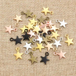 Mixed metallic star pendants in various finishes for DIY jewelry making on linen background