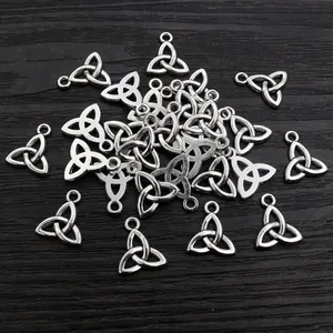 Antique silver Triquetra Celtic knot triangle pendants on dark wood for DIY jewelry making