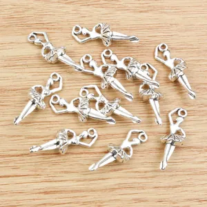 Silver ballet dancer charms for DIY jewelry making scattered on wooden background