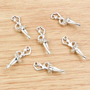 Set of six silver ballerina charm pendants on a rustic wooden background for DIY jewelry