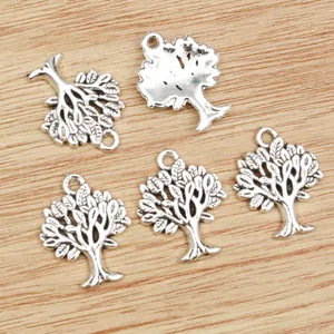 Five silver tree of life alloy charms for DIY jewelry on a rustic wooden background