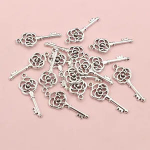 Macro detail of antique silver alloy key pendants with rose hollow patterns for DIY jewelry