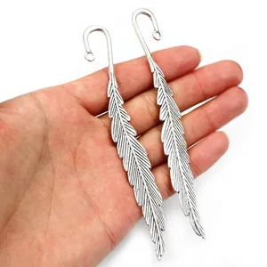 Alloy feather pendants in vintage silver on a palm to show the scale and texture