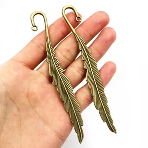 Detailed close-up of large bronze feather pendant showing fine metal textures and loop