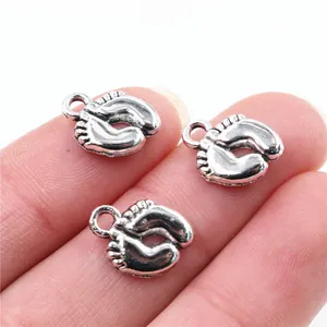 Macro de pendentifs pieds de bébé sur le bout du doigt pour référence de taille DIY