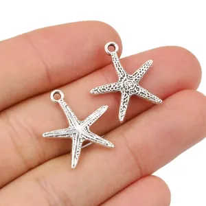 Starfish alloy charms in antique silver finish for DIY jewelry making on fingertip