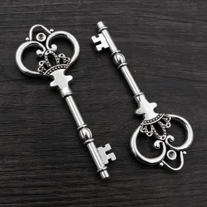 Vintage silver alloy key charms with ornate crown and heart engraving on wooden background