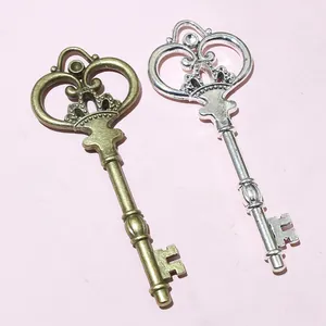 Close-up of heart crown hollow key pendants in antique bronze and silver alloy finish