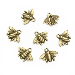 Macro detail of antique bronze bee charms with intricate wing textures for DIY jewelry