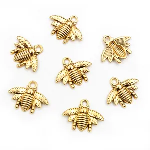 Detailed close-up of seven golden bee alloy charms for DIY necklace and bracelet jewelry
