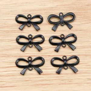 Detailed view of six matte black bow-shaped alloy pendants for DIY jewelry making
