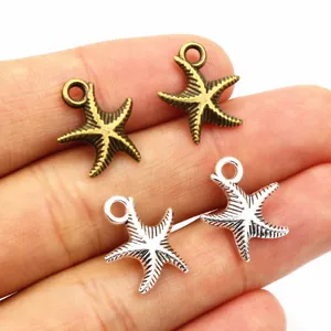 Antique silver and bronze starfish alloy charms shown in hand for size reference