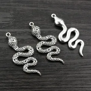 Detailed view of alloy snake pendants with textured and polished silver finishes
