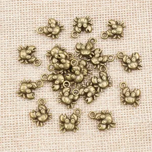 Antique bronze crab charms for DIY jewelry making on a rustic linen background