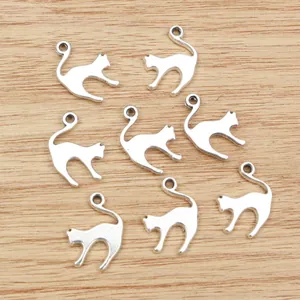 Eight silver alloy cat charms for DIY jewelry making on a light brown wooden background
