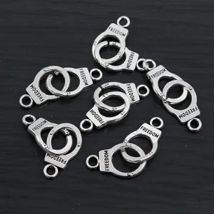 Detailed macro view of silver alloy handcuff pendants with freedom engraving for DIY jewelry