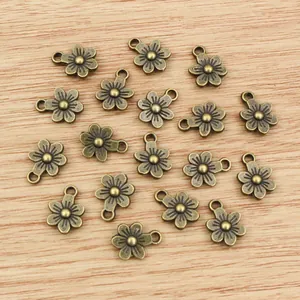 Colgantes de flores en aleación de bronce antiguo para bisutería en fondo de madera
