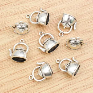Eight pieces of 3D alloy teapot charms for DIY jewelry making on wood background