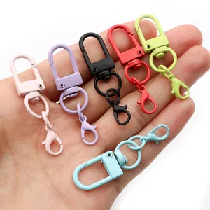 Handheld view of six colorful matte U-shaped lobster clasps for DIY bag accessories