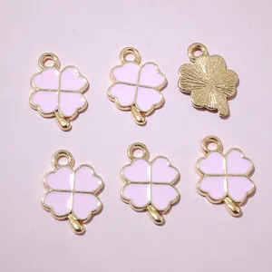 Détail de pendentifs trèfle en émail rose avec dos en métal doré texturé
