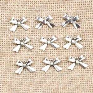 Silver alloy bow pendants for DIY jewelry making with polished metal finish and pre-drilled holes