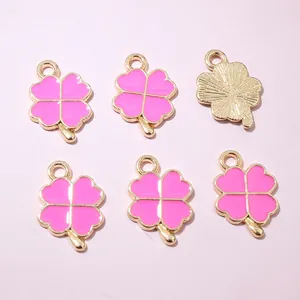 Détails de pendentifs trèfles en émail rose avec monture dorée et texture au dos