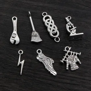 Set of seven vintage silver alloy charms including wrench broom and microscope pendants