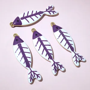 Dettaglio di quattro ciondoli a lisca di pesce in smalto viola e bianco per gioielli DIY