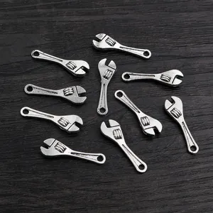 Ten vintage silver alloy wrench charms with hanging holes for DIY jewelry on wood