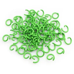 Dettaglio macro di anellini aperti verde erba per creazione di gioielli DIY