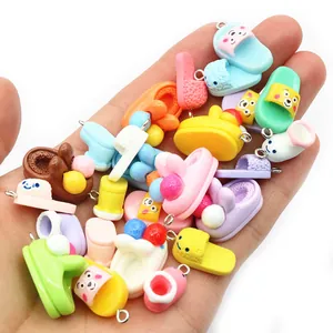 Colorful resin mini shoe pendants in hand showing variety of cute cartoon styles