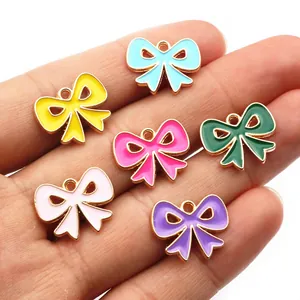 Colgantes de lazo coloridos de aleación esmaltada para joyería DIY mostrados en mano